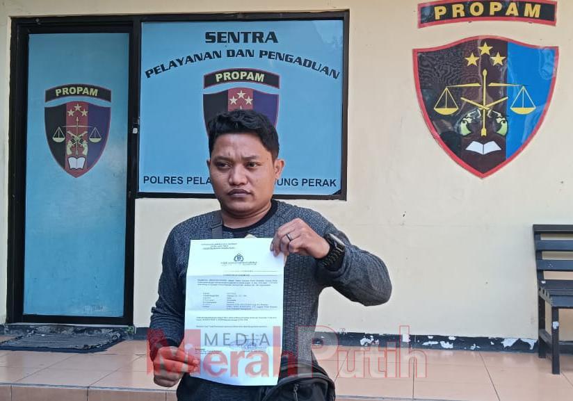 Korban penipuan dan penggelapan, Sayyadi (33) setelah mendatangi sebagai saksi pelapor di Propam Polres Pelabuhan Tanjung Perak membeberkan surat tanda penerimaan laporan, Selasa, (11/6/2024). | MMP I Dhimas 