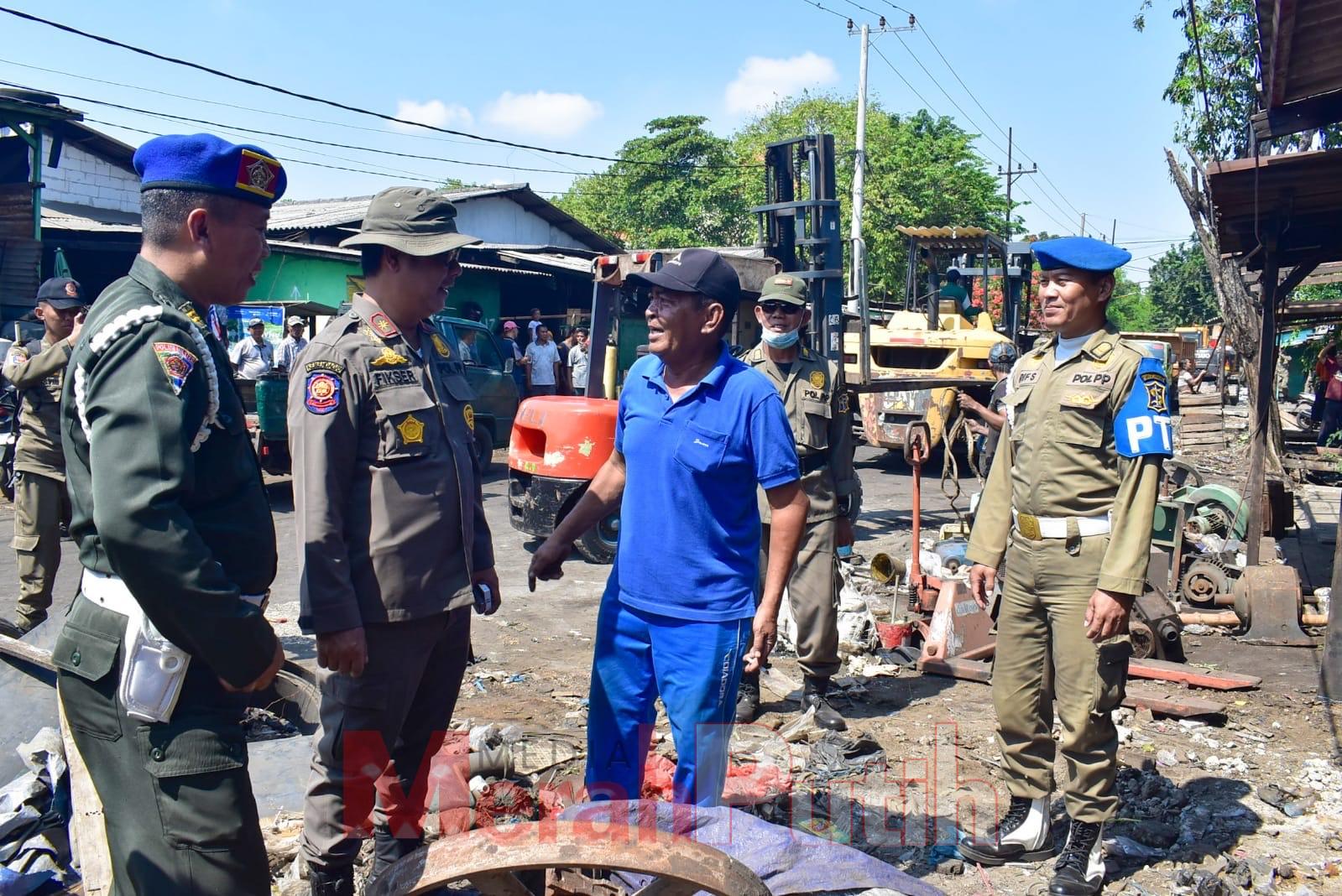 Petugas Satpol PP Surabaya membongkar ratusan bangunan PKL di Pasar Loak Dupak Rukun, Senin (08/07). Selain mengganggu akses jalan menuju ke sekolah, penataan PKL di Jalan Dupak Rukun ini dilakukan karena terdapat beberapa bangunan semi permanen milik par