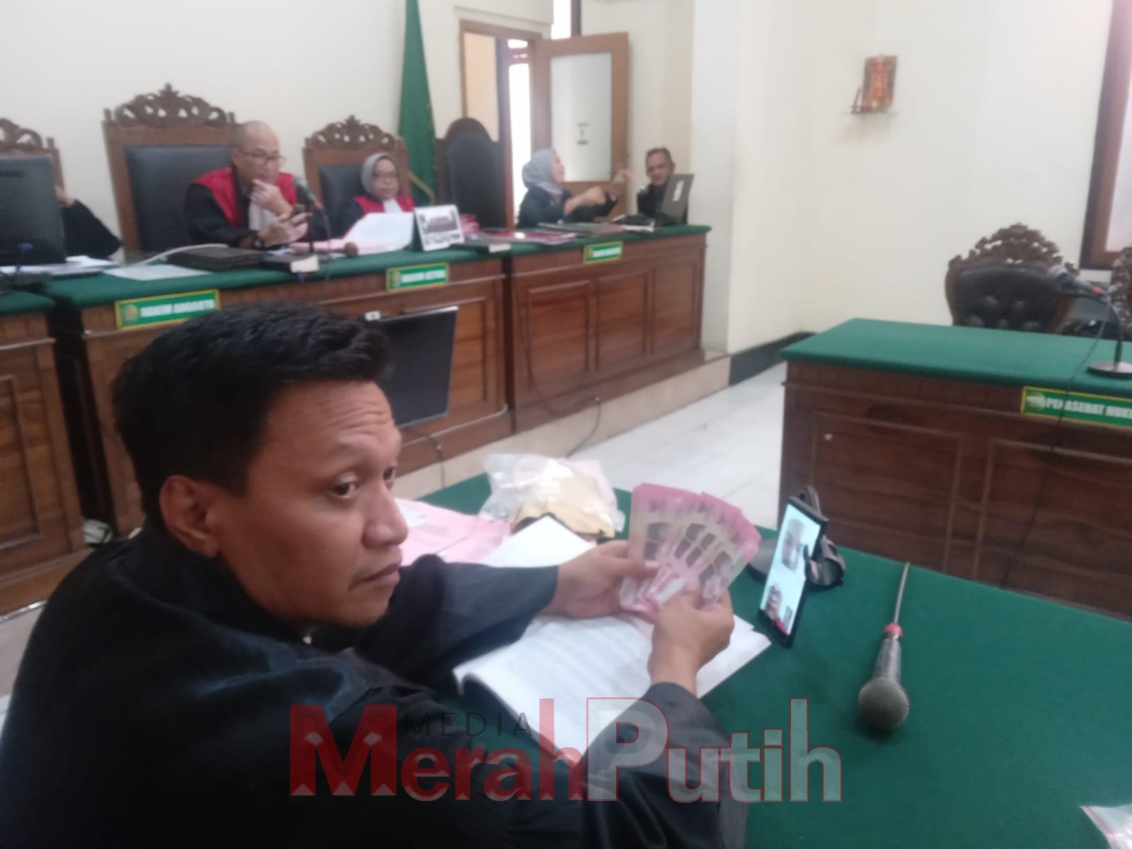 Jaksa Penuntut Umum (JPU) Suparlan menunjukan barang bukti uang palsu pecahan Rp 100 ribu diperoleh dan diedarkan oleh terdakwa In'amul Hasan Abdullah dari Iswanto Wahyudi melalui media sosial (sosmed) Facebook dan WhatsApp di Pengadilan Negeri (PN) Surab