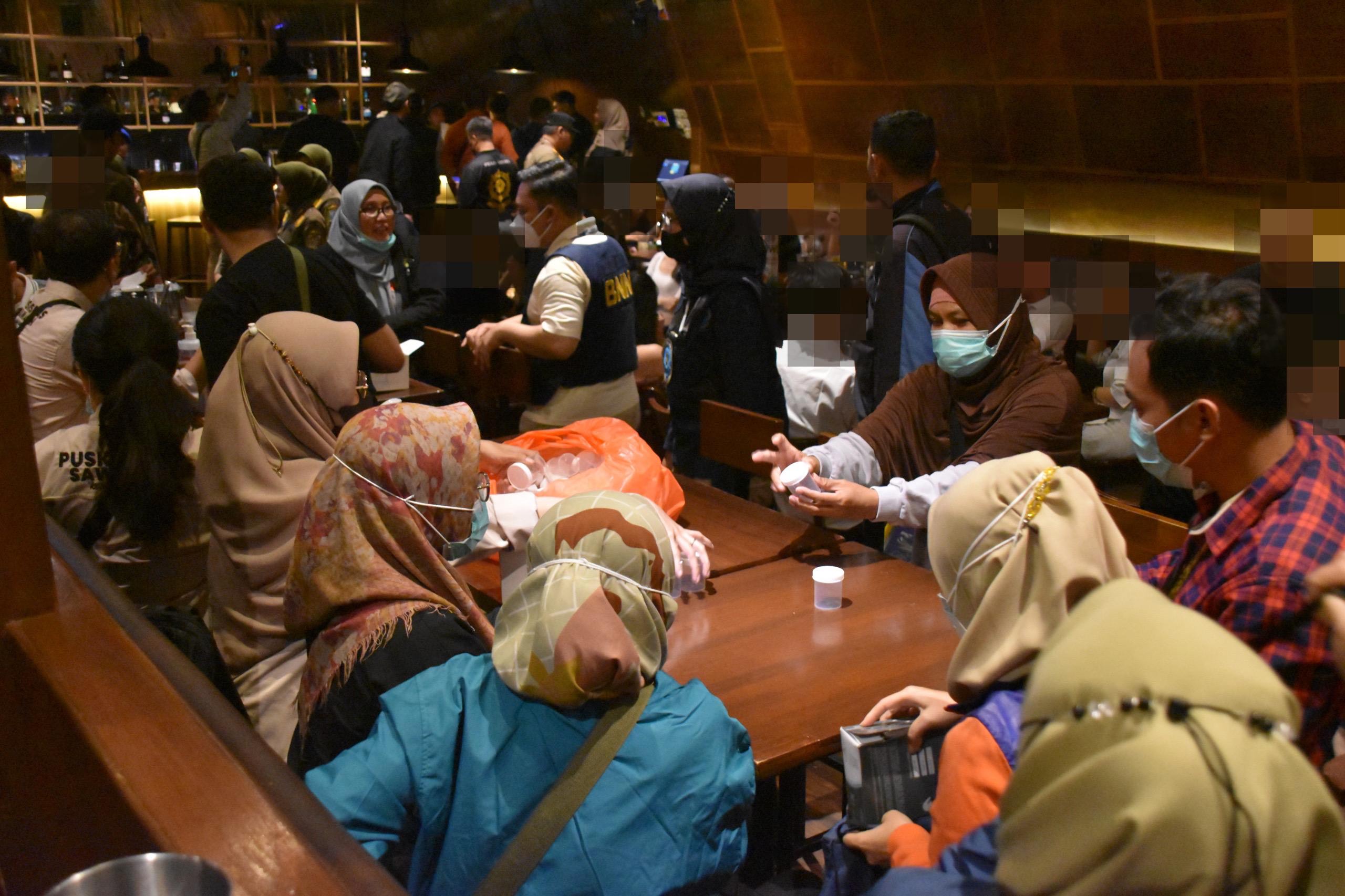 Petugas Badan Narkotika Nasional (BNN) melakukan tes urine pada pengunjung dua tempat Rekreasi Hiburan Umum (RHU) di kawasan Surabaya Barat, Sabtu (21/12) dini hari 