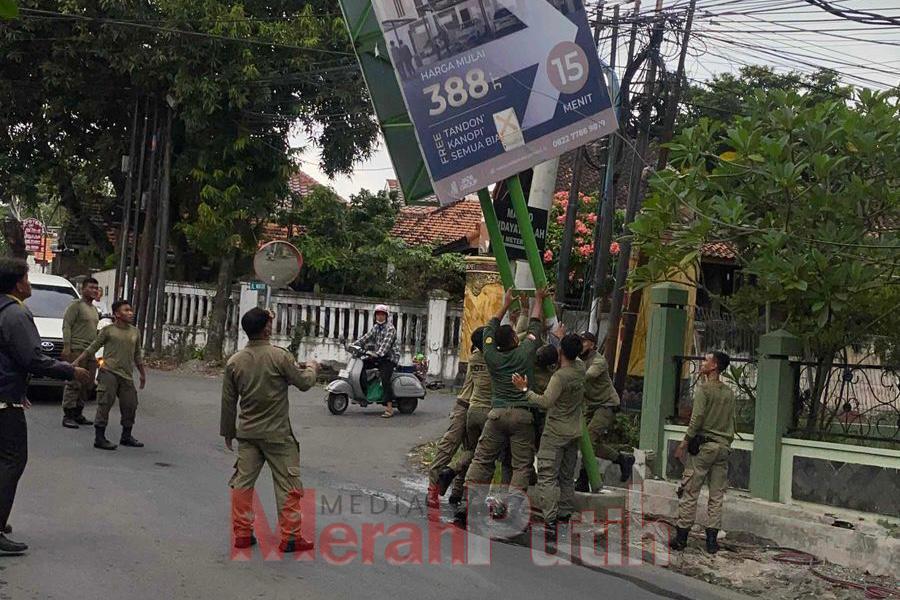 Petugas Satpol PP membongkar tiang reklame berukuran 2 x 3 meter yang tidak memiliki izin resmi dan terpasang di bahu jalan Raya Made, Rabu (26/03) I MMP I dok Pemkot
