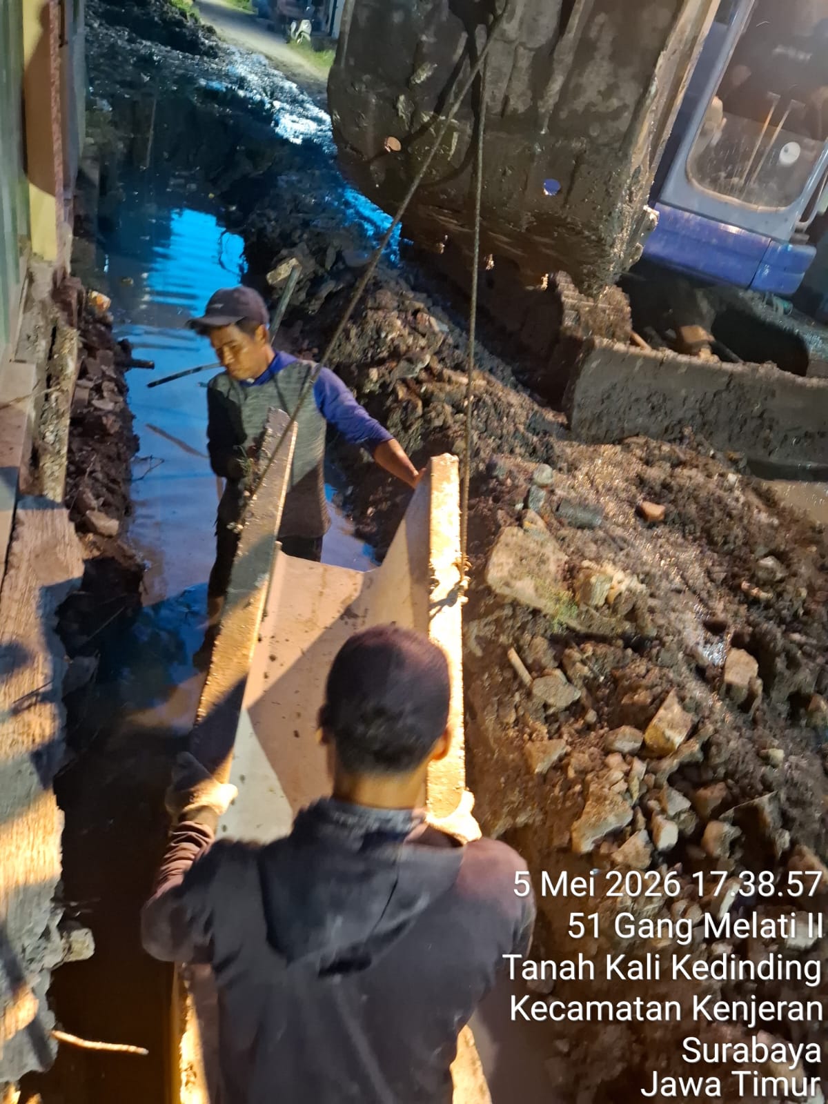 Pekerja memasang U-ditch dalam kondisi saluran masih tergenang air di lokasi proyek Gang Melati II, Kenjeran, Surabaya. Kondisi ini menuai pertanyaan terkait metode pelaksanaan pekerjaan dan standar teknis konstruksi | MMP | dok