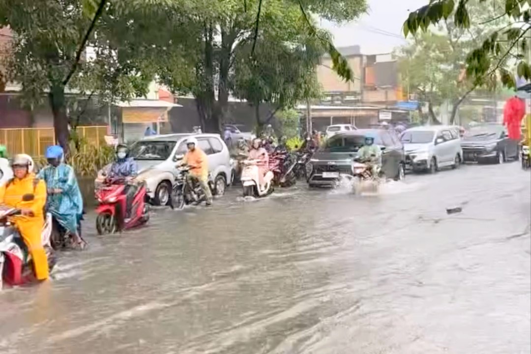 Kondisi banjir di Jalan Sukomanunggal usai diguyur hujan deras sejak sejak Selasa (23/6) dini hari memicu banjir di sejumlah titik kota merendam kawasan permukiman hingga jalan protokol dan menjadi banjir kedua dalam sepekan setelah peristiwa serupa pada 